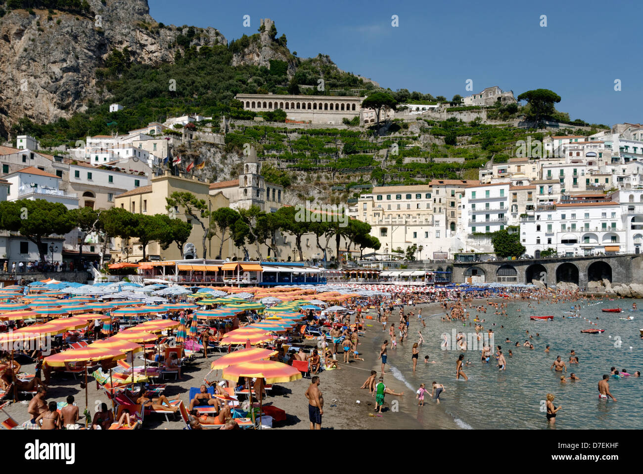 Masses of people swimming, sunbathing or resting under beach umbrellas ...