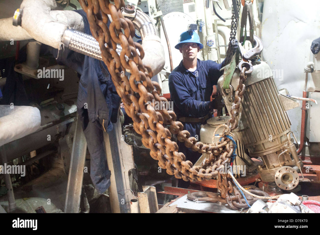 A Sailor removes equipment from the former USS Guardian. Stock Photo