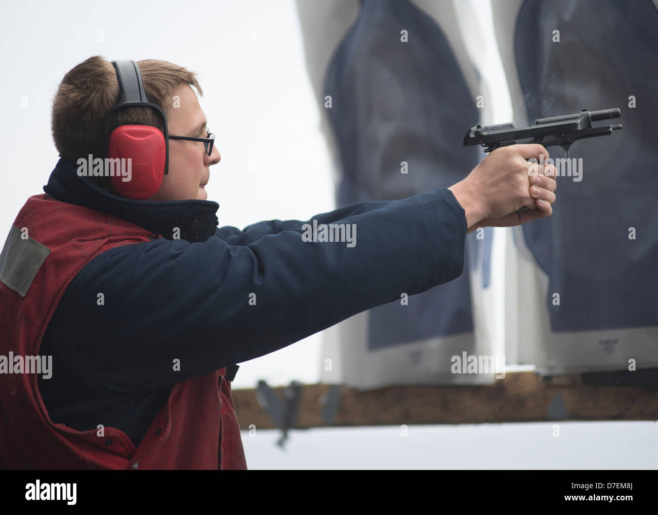 A Sailor fires an M9 pistol aboard USS Boxer. Stock Photo