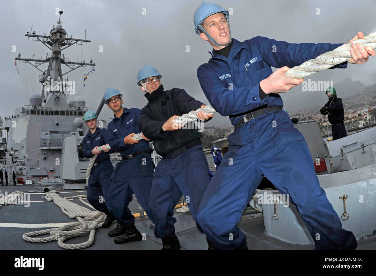 Sailors handle a mooring line aboard USS Jason Dunham. Stock Photo