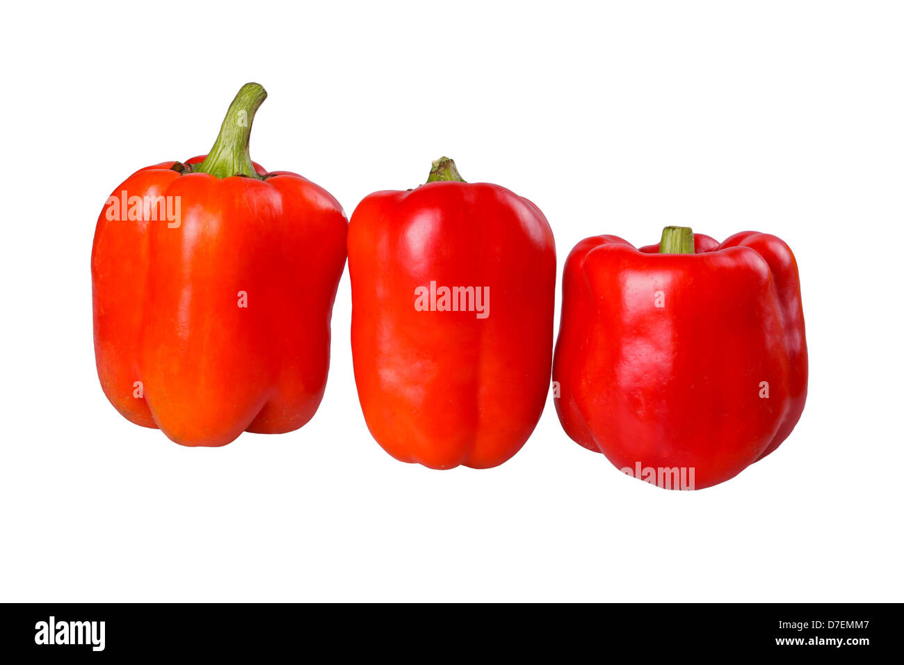 Three red, ripe bell pepper fruits (Capsicum annuum) in a row isolated against a white background Stock Photo