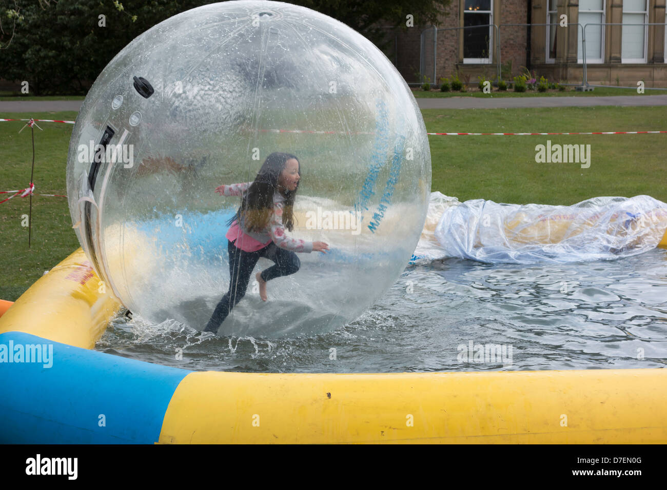 An excited young girl in a water ball Stock Photo
