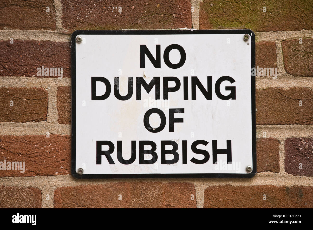 street sign No Dumping of Rubbish fixed to wall in Exeter Devon England UK Stock Photo