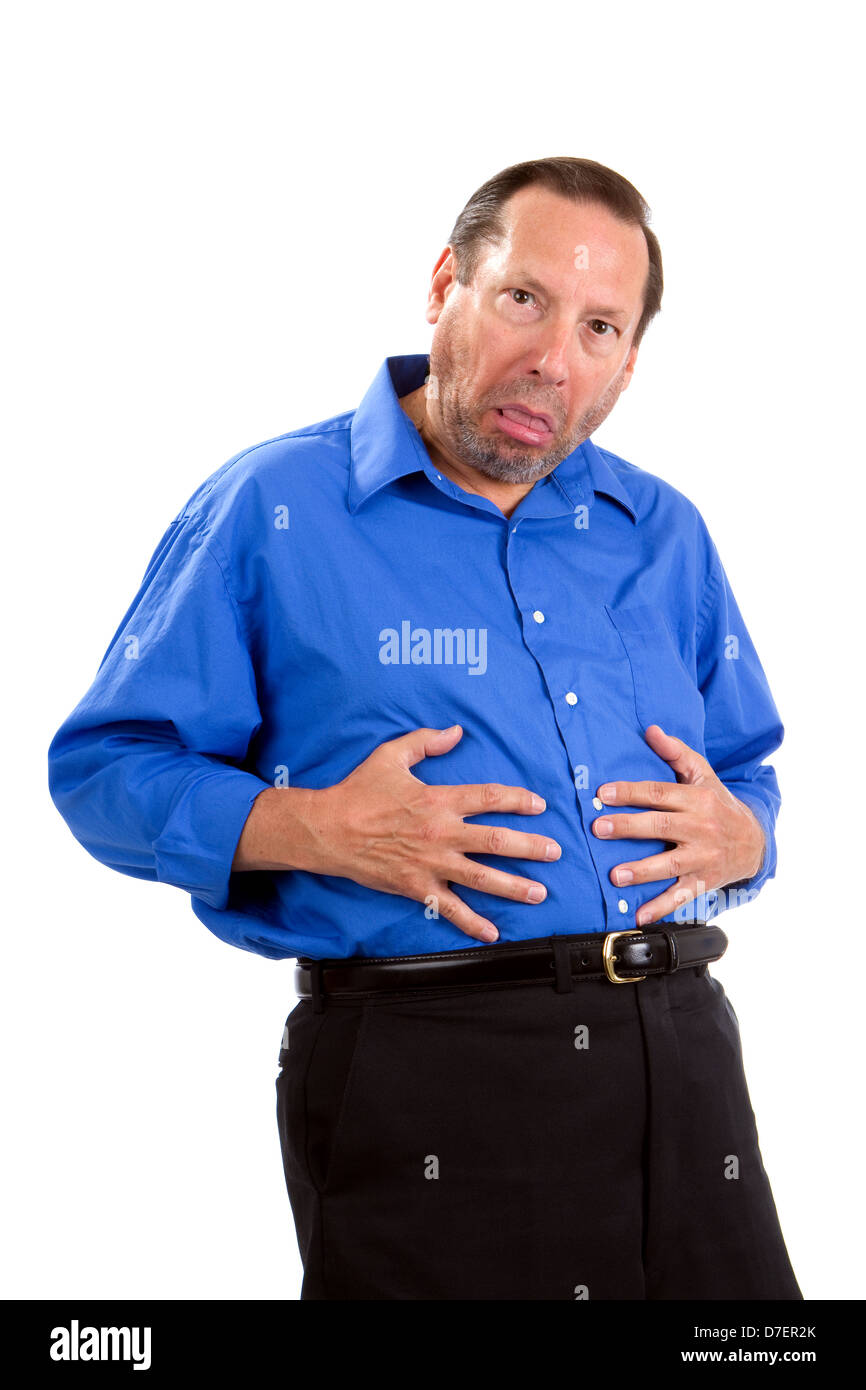 Senior adult man holds his belly as his feels sick with a stomachache and has a humorous look on his face. Stock Photo
