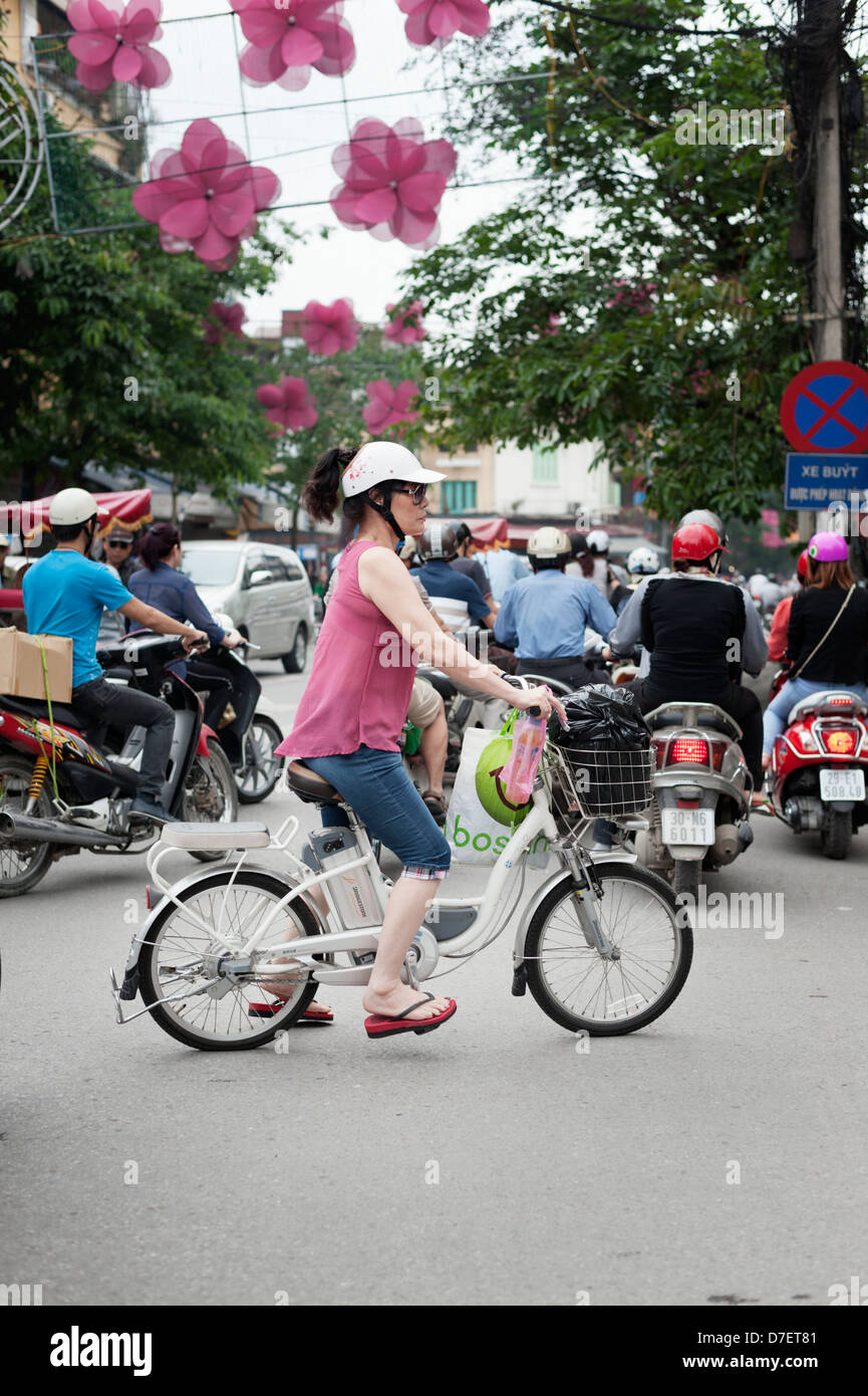 Hanoi, Vietnam - a woman riding an electric scooter bike in traffic Stock Photo