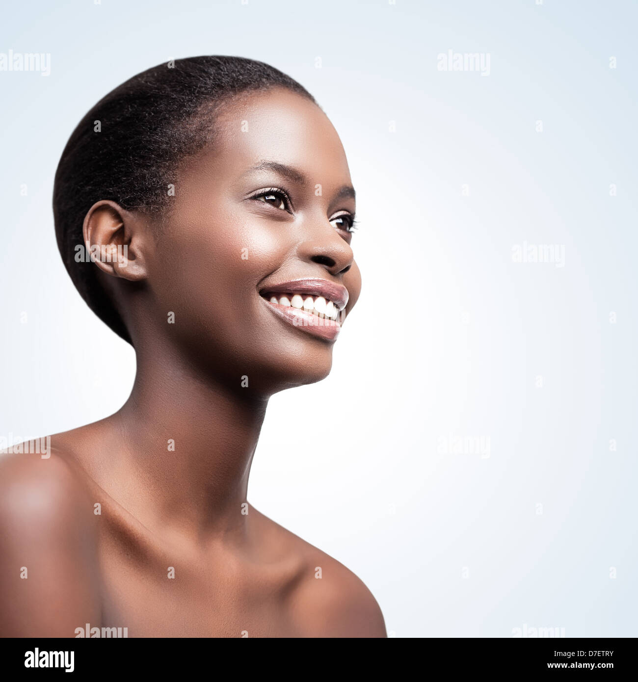 Portrait of a beautiful African woman posing in front of a blue background. Stock Photo