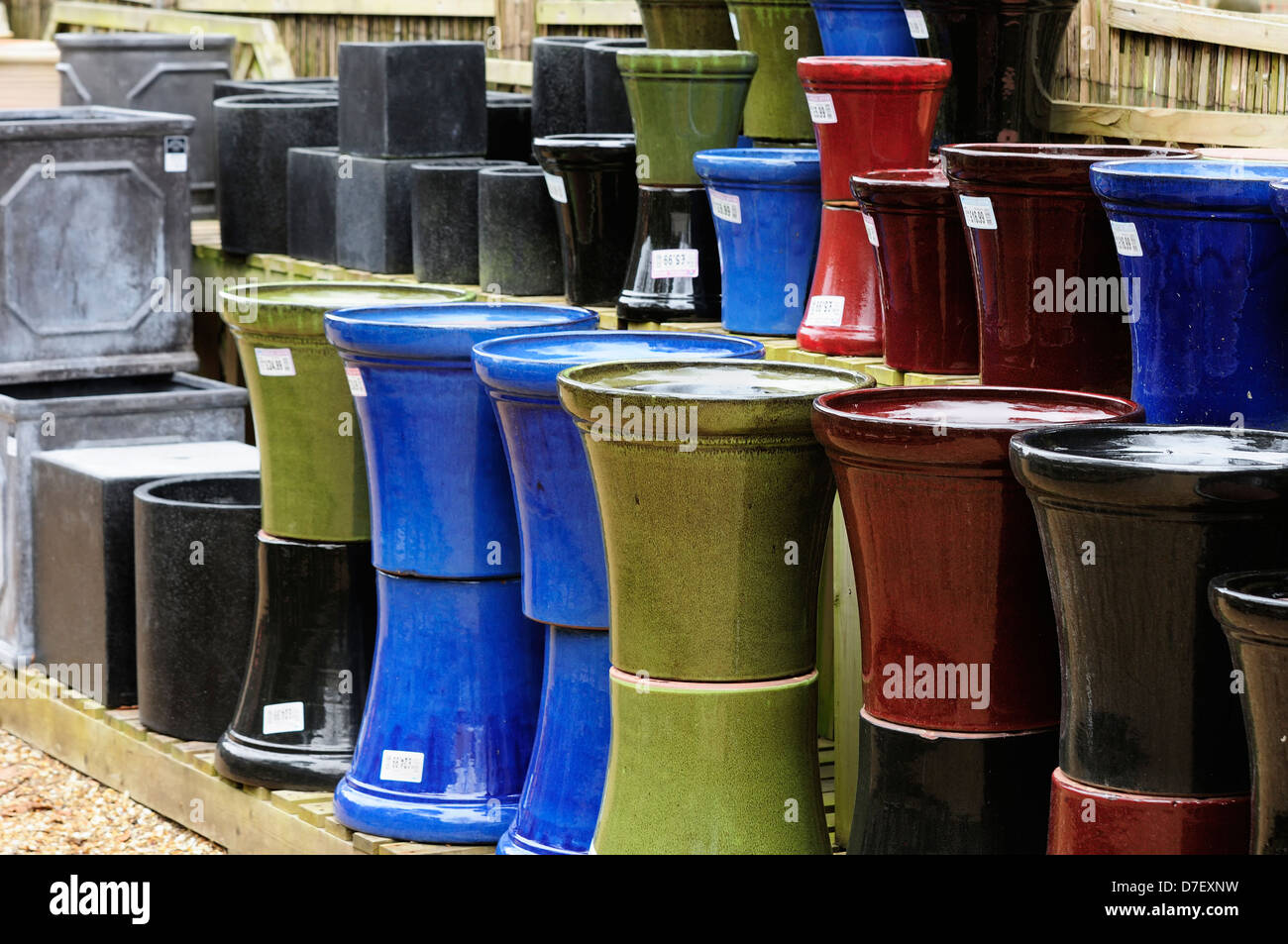 A selection of glazed and coloured plant pots on display at a garden