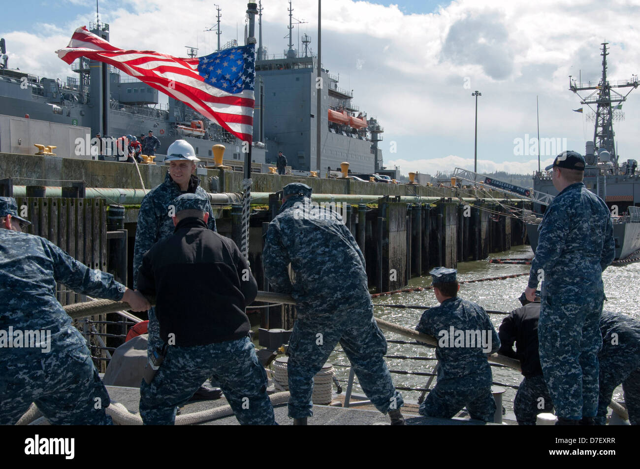 Sailors heave lines to get underway. Stock Photo