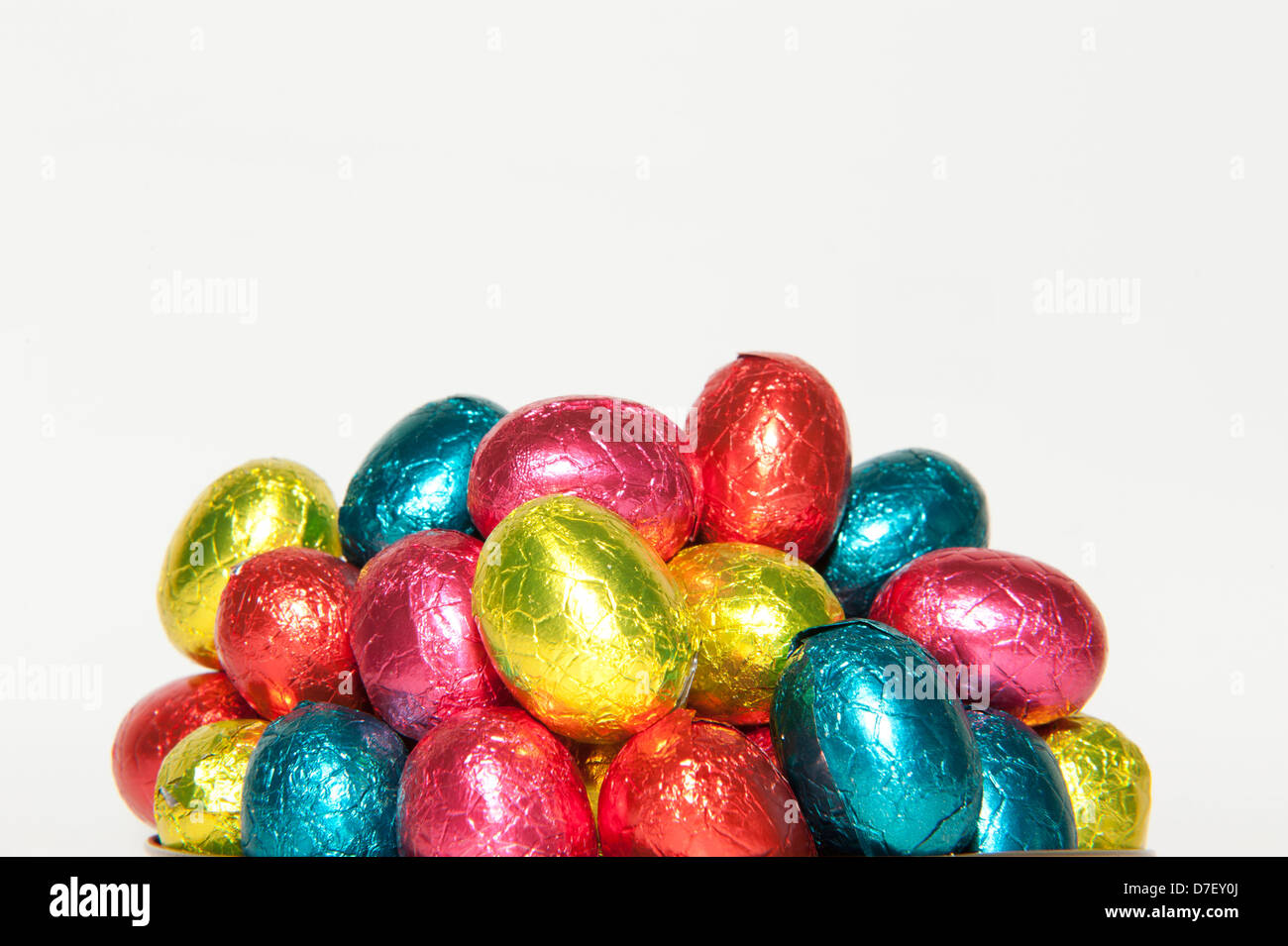 Colored chocolate Easter eggs packed in a pile and in closeup, isolated