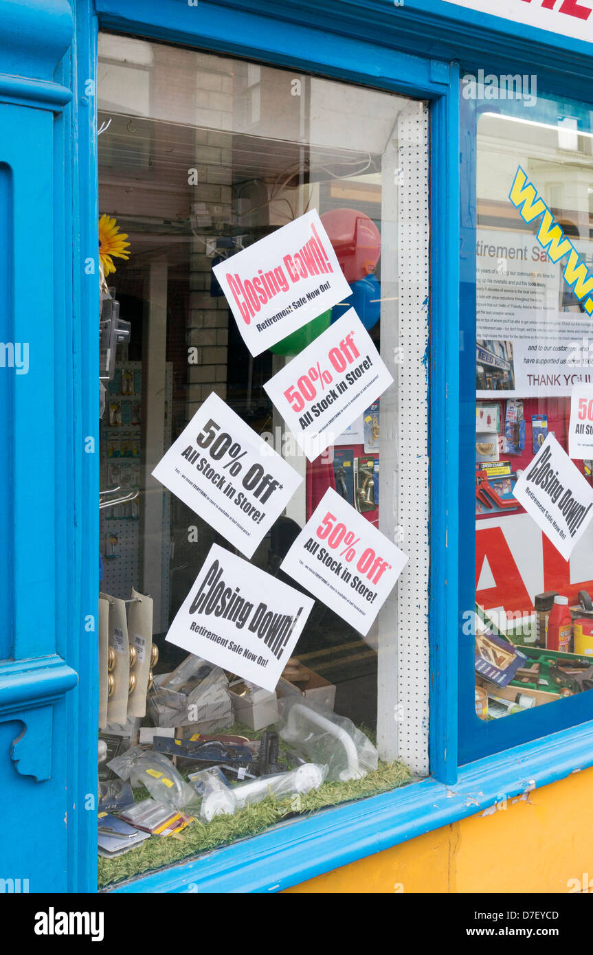 Small posters in the window of a shop advertising reductions due to it closing down Stock Photo