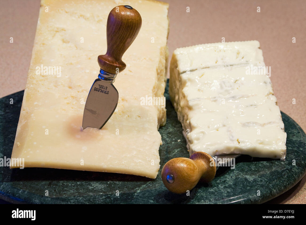 A block of parmesan and cheese on a marble round board with