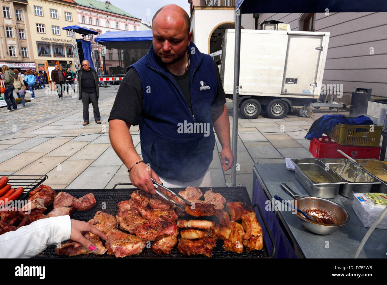 Czech cook preparing grill meat in Olomouc Square celebrating May 1 Stock Photo