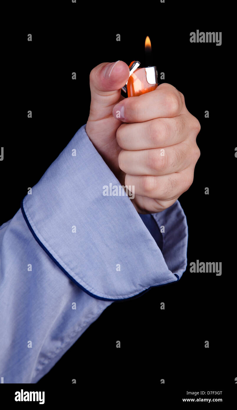 A young adult caucasian man's hand coming out sleeve blue/azul cotton robe igniting simple disposable plastic orange lighter. Stock Photo