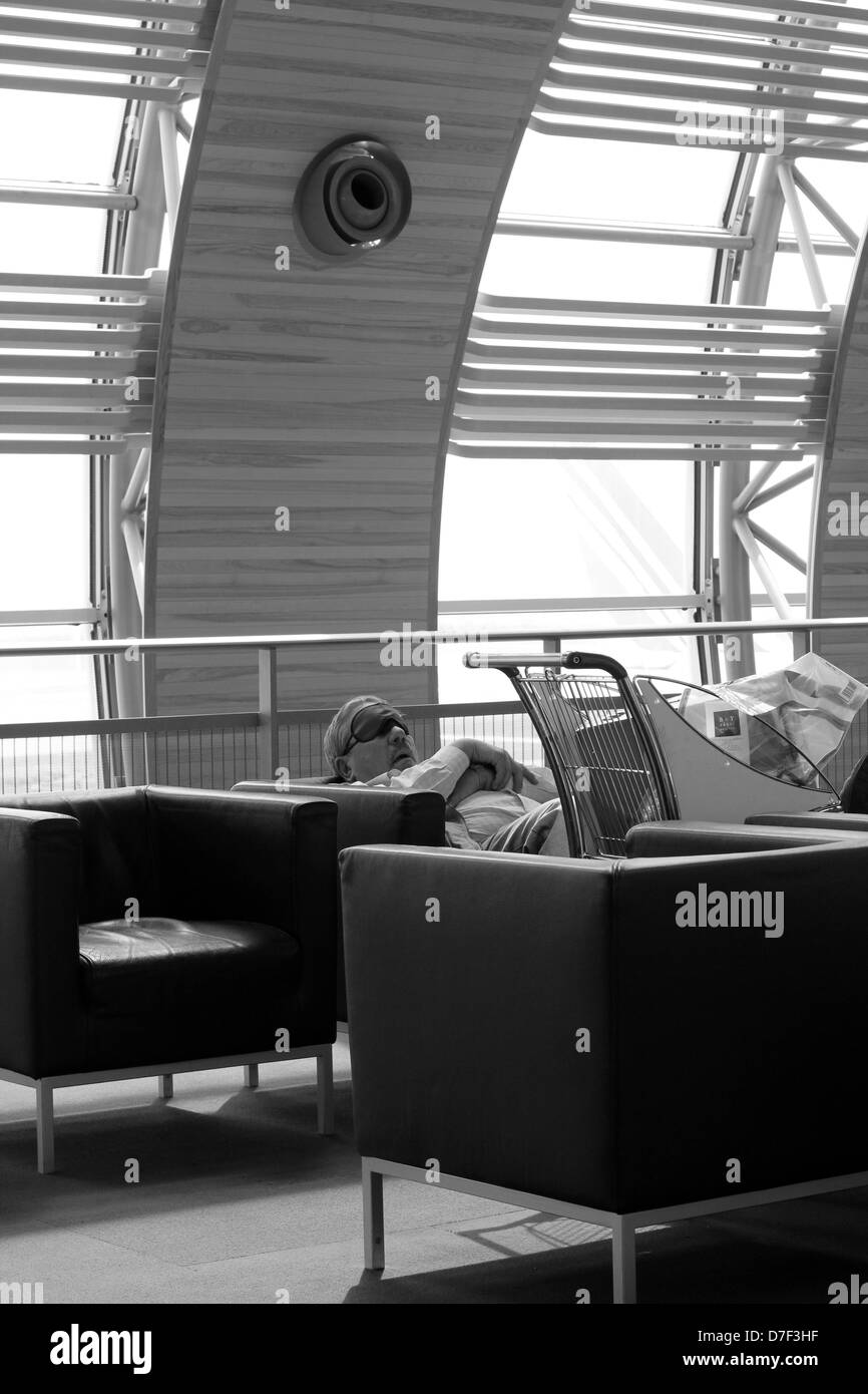 Passenger sleeping in airport Charles De Gaulle, Paris, France Stock