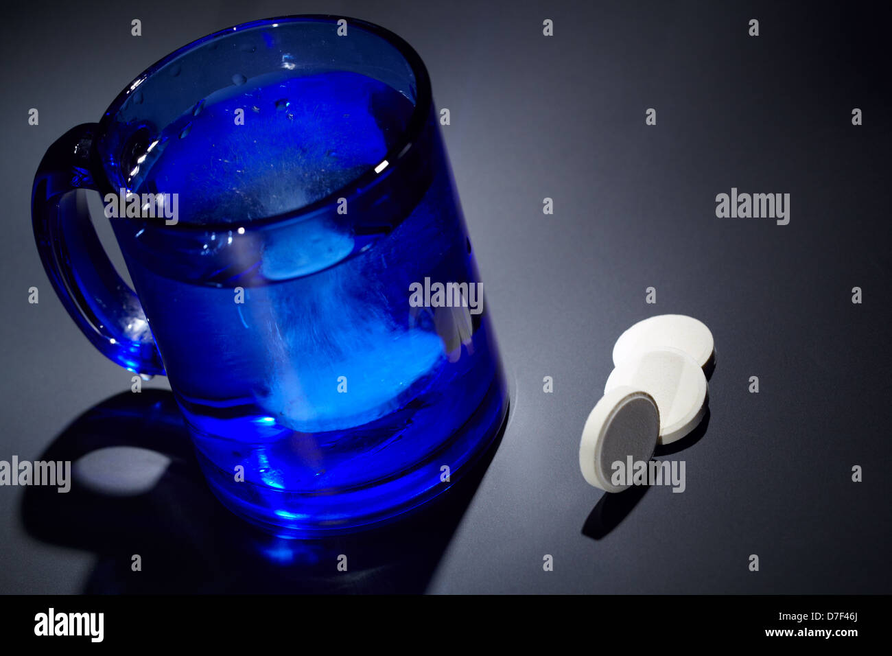 Vitamin C tablet dissolving in a blue glass of water Stock Photo Alamy
