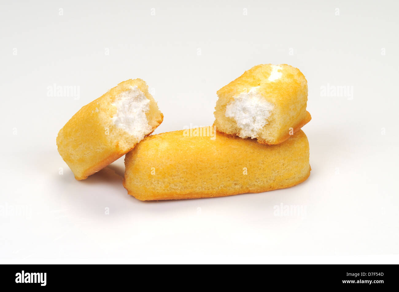 Twinkies split in half with vanilla creme filling visible on white background cutout. USA Stock Photo