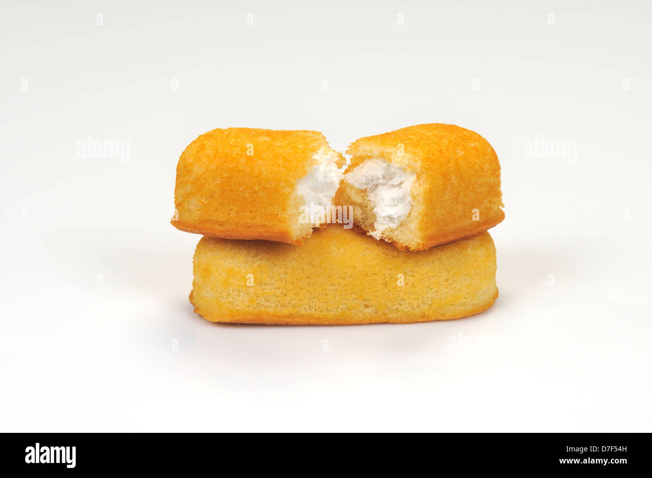 Hostess Twinkies on top of each other with 1 cut in half and creme filling visible on white backgound, cutout. USA Stock Photo