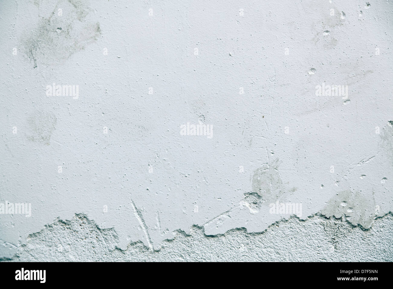 Close up of astained wall, of which the paint is peeling and revealing the plaster beneath. Stock Photo