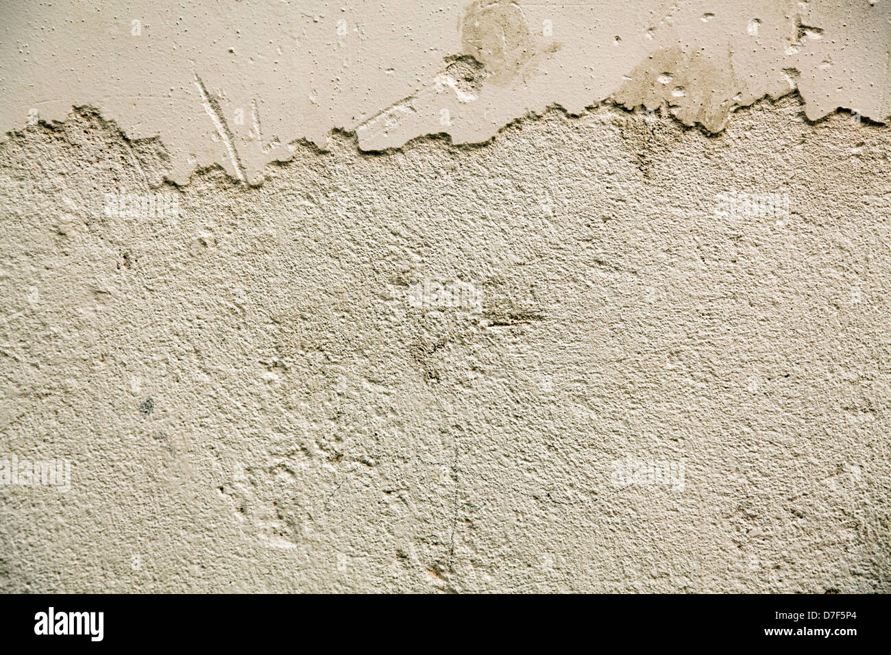 Close up of a stained wall, of which the paint is peeling and revealing the plaster beneath. Stock Photo