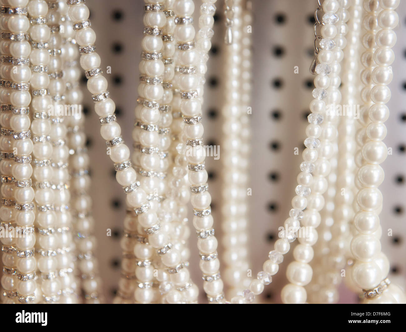 fake pearl necklaces hanging for sale in shop Stock Photo