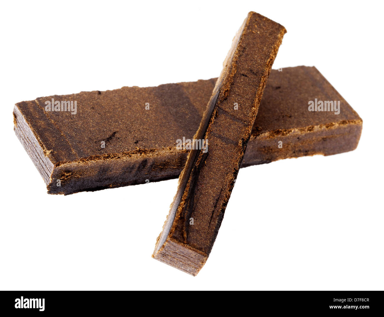 A 10 grams piece Hashish laid on top 20 grams piece isolated on white background. This pieces represent quantity three retail Stock Photo
