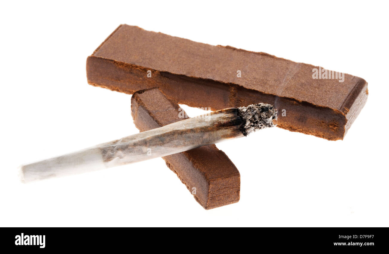 how much is 30 grams of tobacco A lit joint laid on two pieces of Hashish (about 30 grams), isolated on  white background Stock Photo