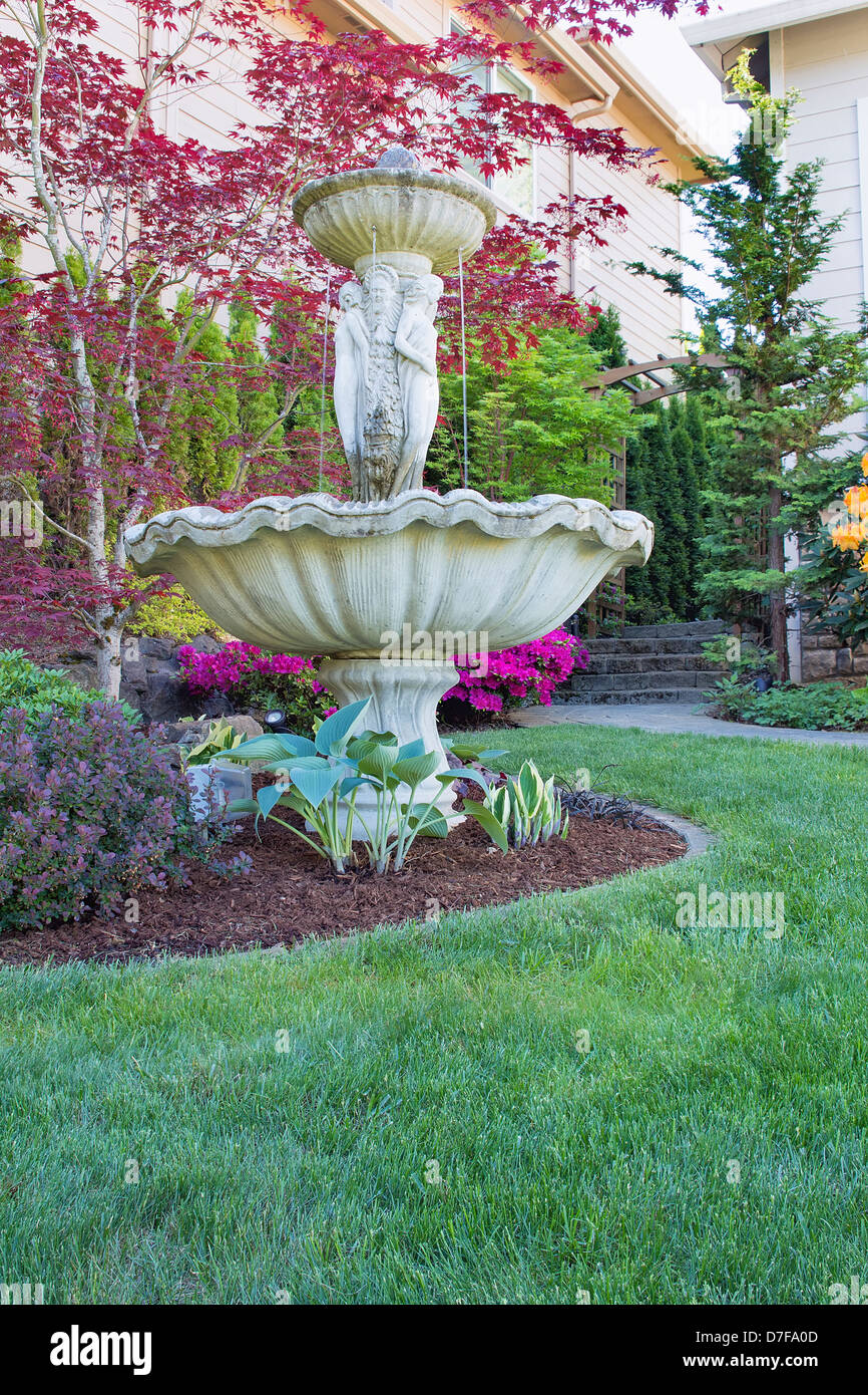 Renaissance Water Fountain on Front Lawn Landscaping with Trees and Flowering Shrubs Stock Photo