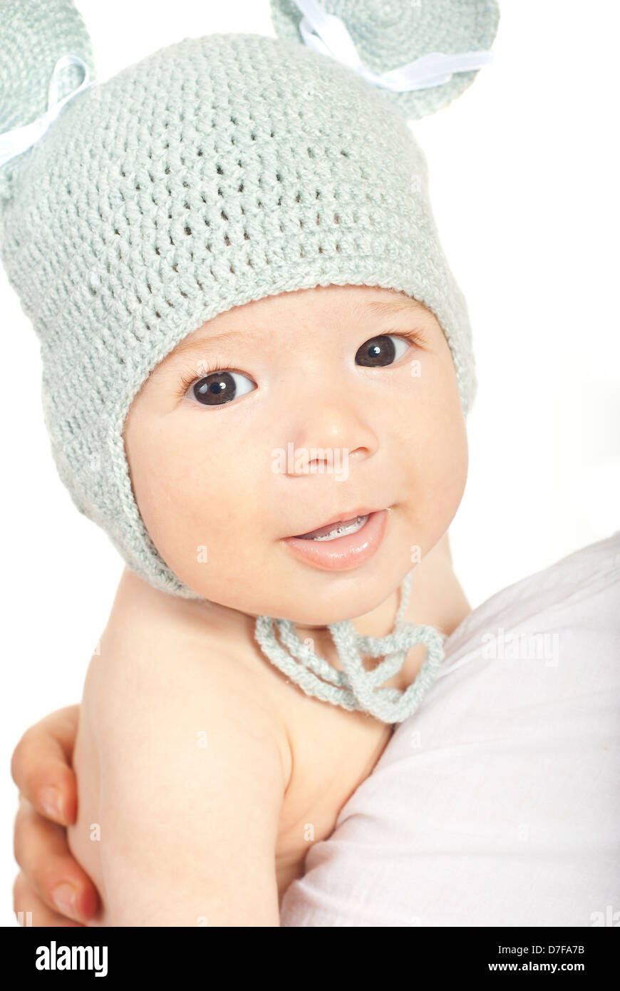 Beautiful newborn baby with knitted wool cap on mother shoulder isolated on white background Stock Photo