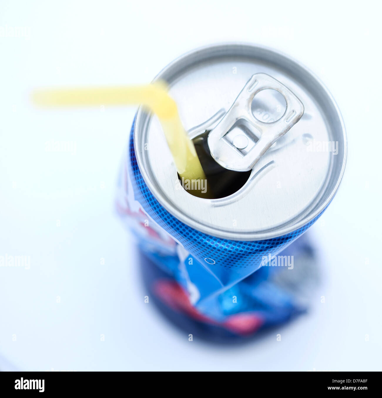Crushed soda can with straw Stock Photo