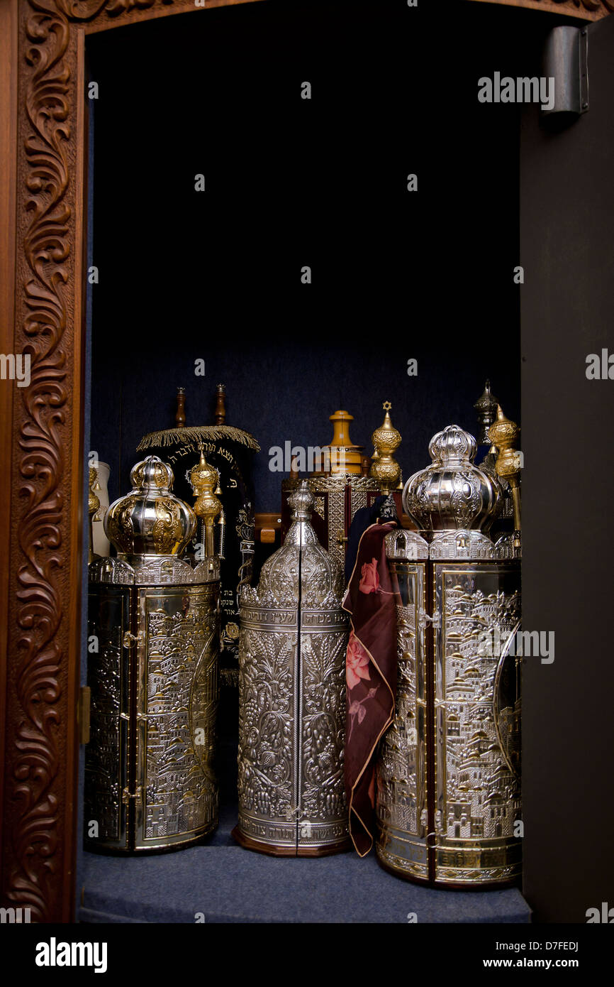 An open cabinet with several Torah (old testament) scrolls closed in