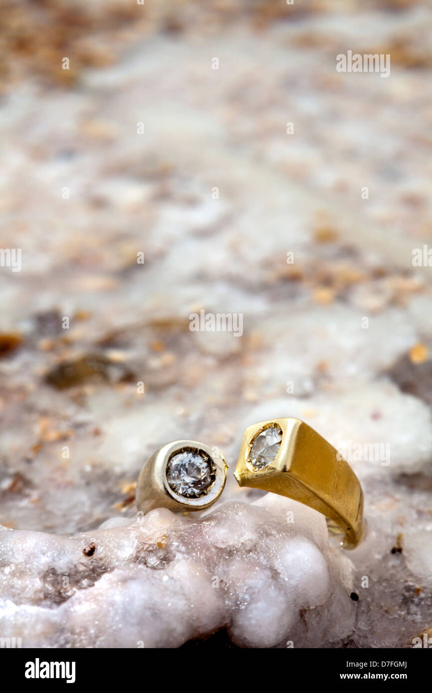 A gold/white gold ring inlaid diamonds resting on salt salt covered rock. Shot on beach infamously salty Dead Sea in Israel. Stock Photo
