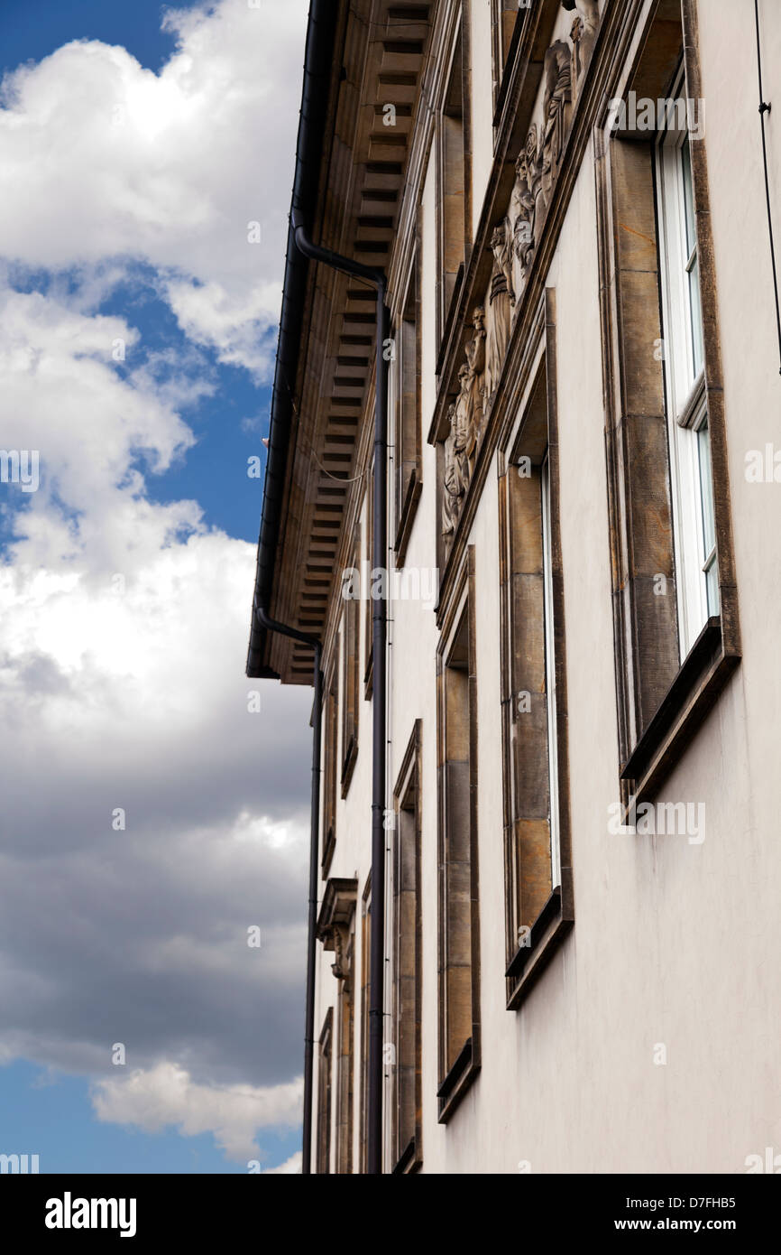 Low angle diminishing view of classic architecture building on the background of cloudy blue sky. Stock Photo