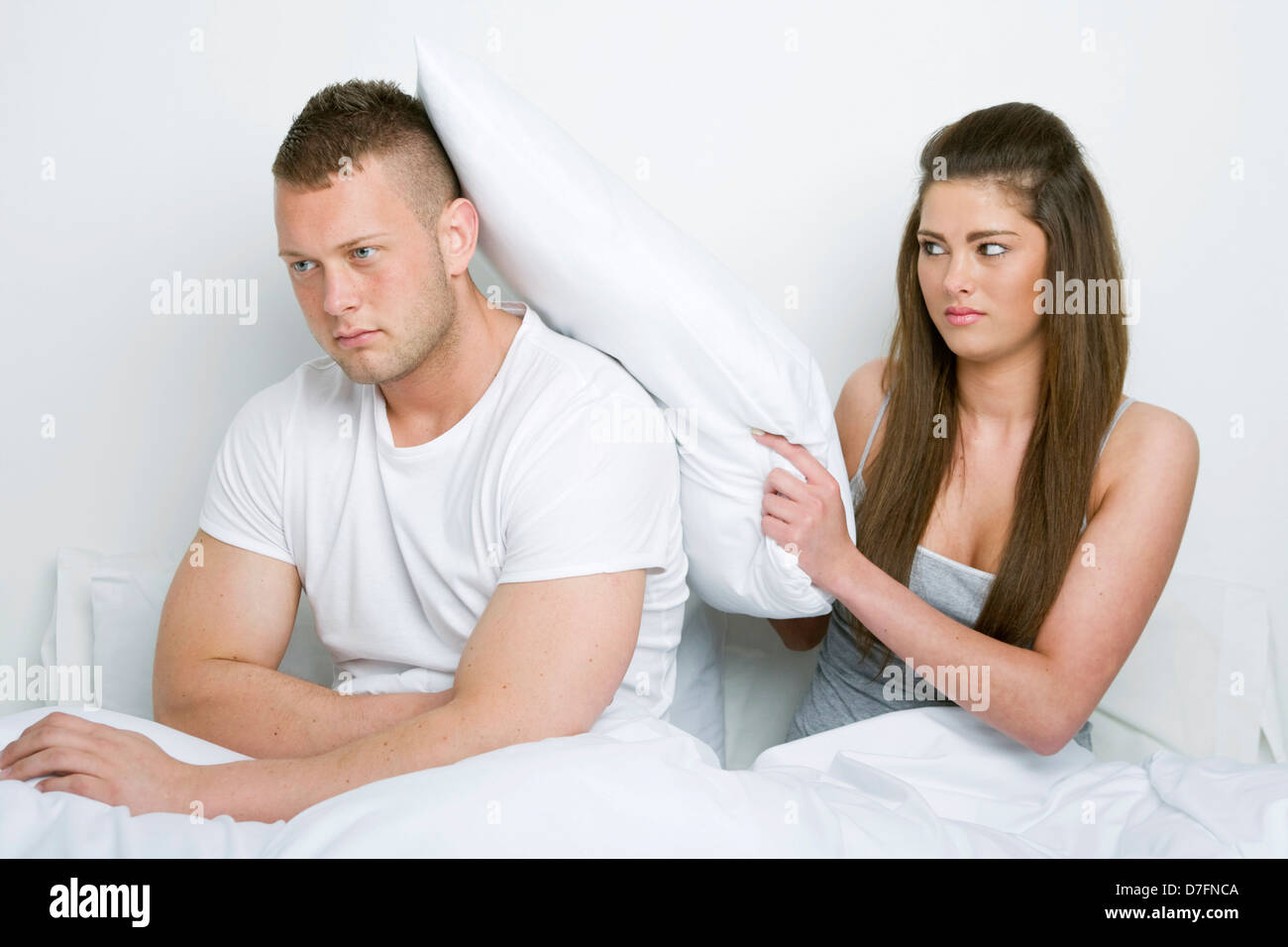 Unhappy young couple fighting in bed. Stock Photo