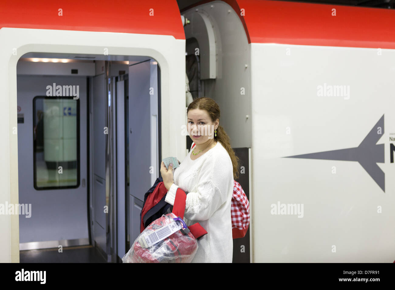 Young woman with bags boarding in Narita express to Tokyo station from airport, Japan Stock Photo