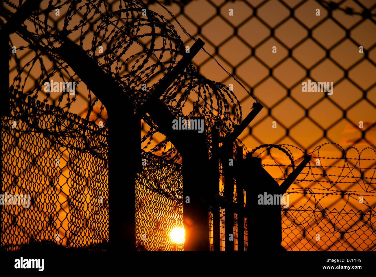 Razorwire and fencing at sunset Stock Photo
