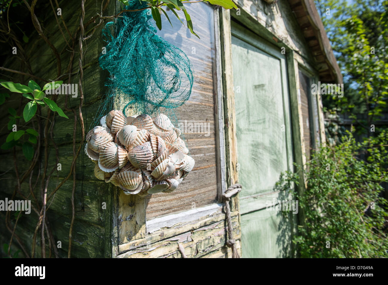 Beach hut in a city garden with lime washed panels and shell decorations Stock Photo
