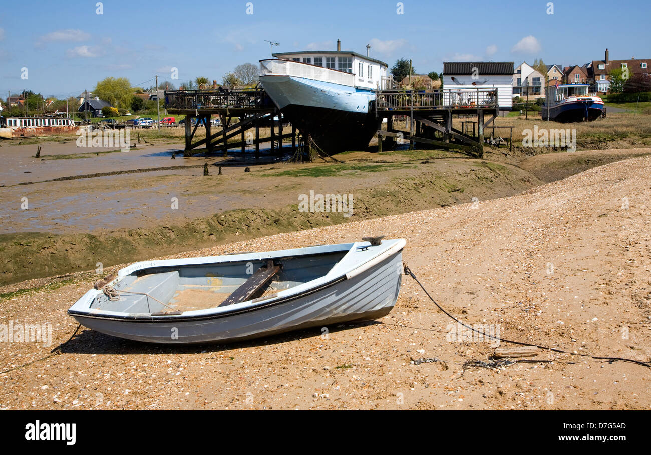 Dinghy on beach and houseboats at West Mersea, Mersea Island, Essex
