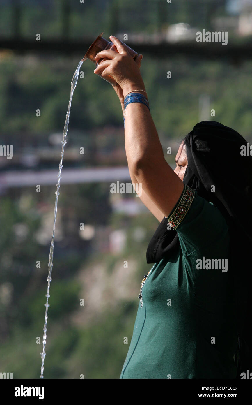 A local woman makes a puja by the holy Bhagirathi River in Uttarkashi. Stock Photo