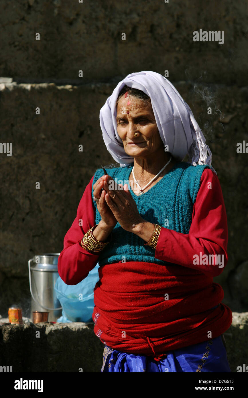 A Garhwali woman prays by the holy Bhagirathi River in Uttarkashi. Stock Photo