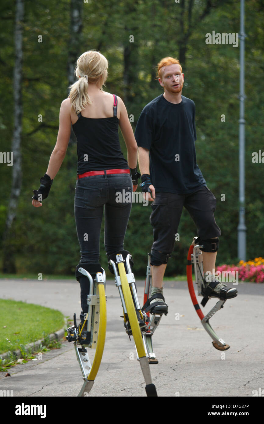 Young people wearing jumping stilts exercising in the park Stock Photo Alamy