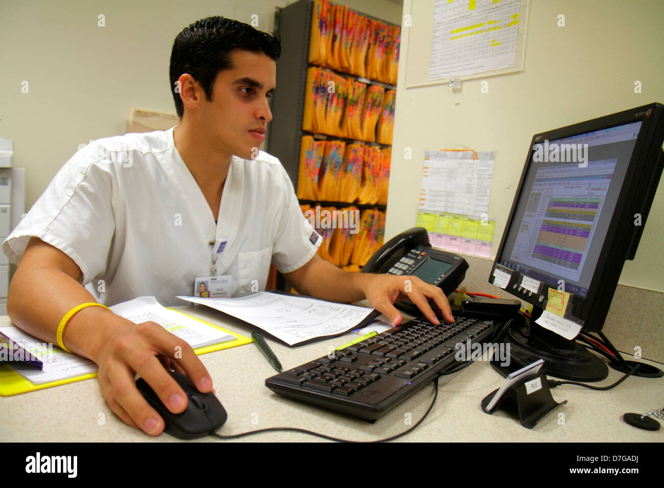 Miami Beach Florida,Mt. Mount Sinai Medical Center,centre,health,doctor's office,accounting department,desk,Hispanic man men male adult adults,using,c Stock Photo