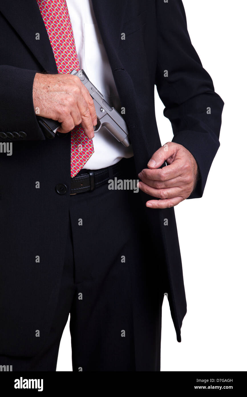 A mature adult man wearing a suit, pulling a 9mm gun out of its holster