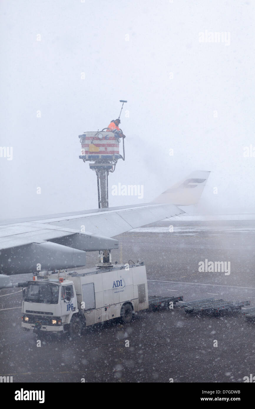 Technical staff in airport runway deicing aircraft wings with fluid