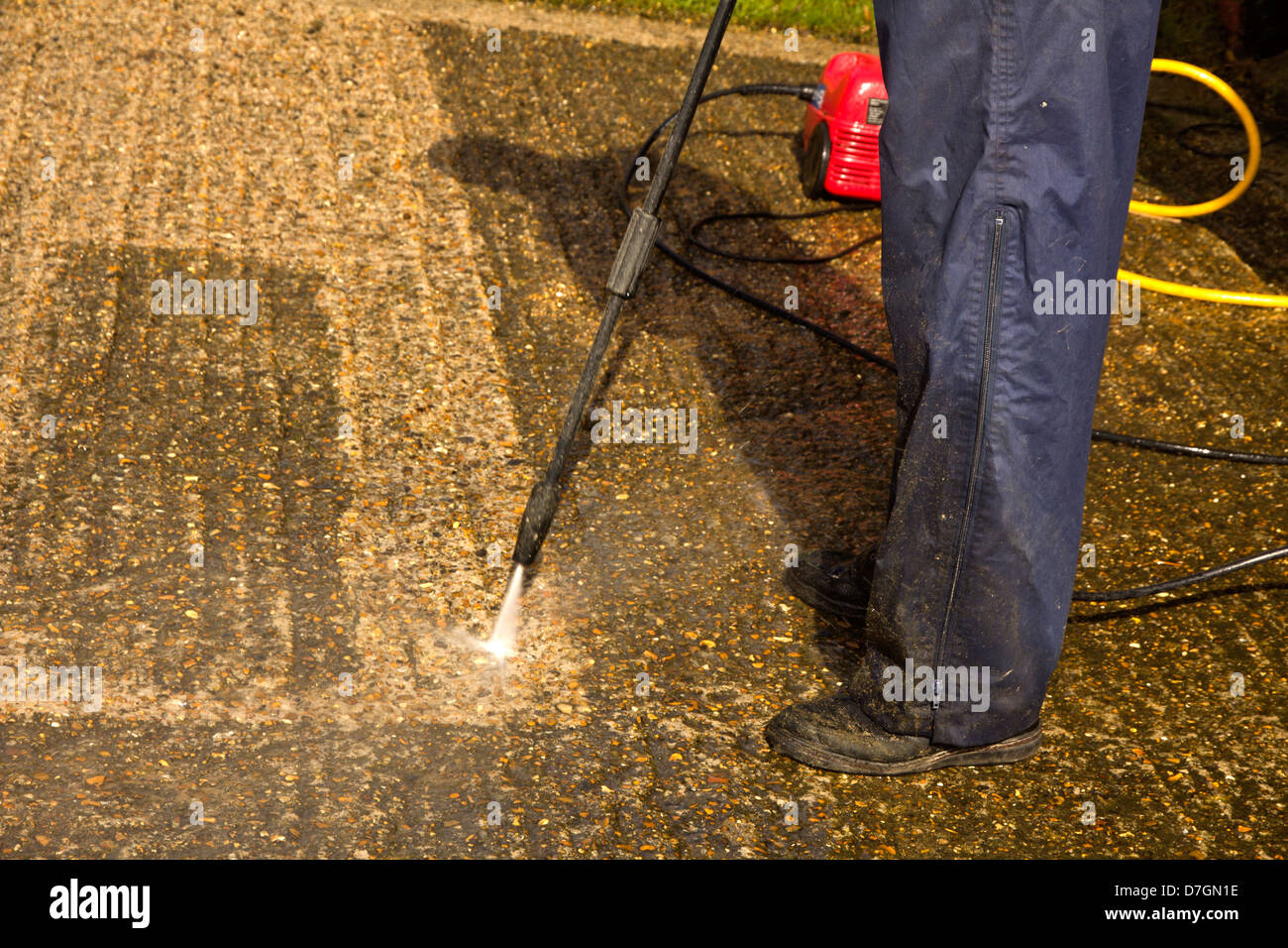 Pressure washing a concrete driveway Stock Photo