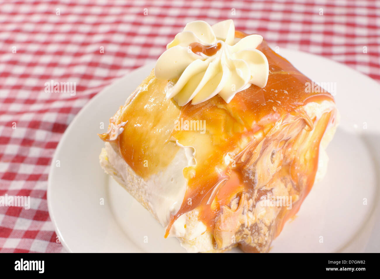 top angle photo of mouth-watering slice of dulce de leche roll with vanilla buttercream icing on top and caramel filling. Stock Photo