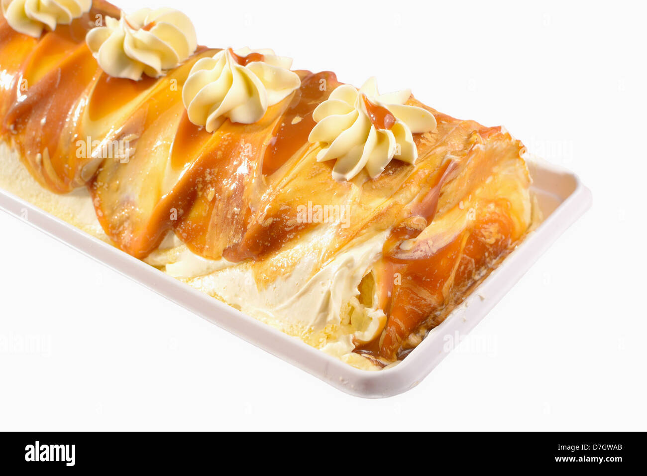 mouth-watering dulce de leche roll with vanilla buttercream icing on top and caramel filling isolated in white background. Stock Photo