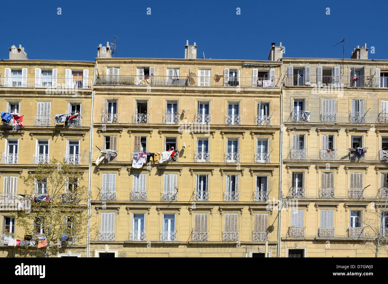 Facade of Traditional Apartment Building with Laundry, Clothes or Washing Hanging Out to Dry Marseille France Stock Photo