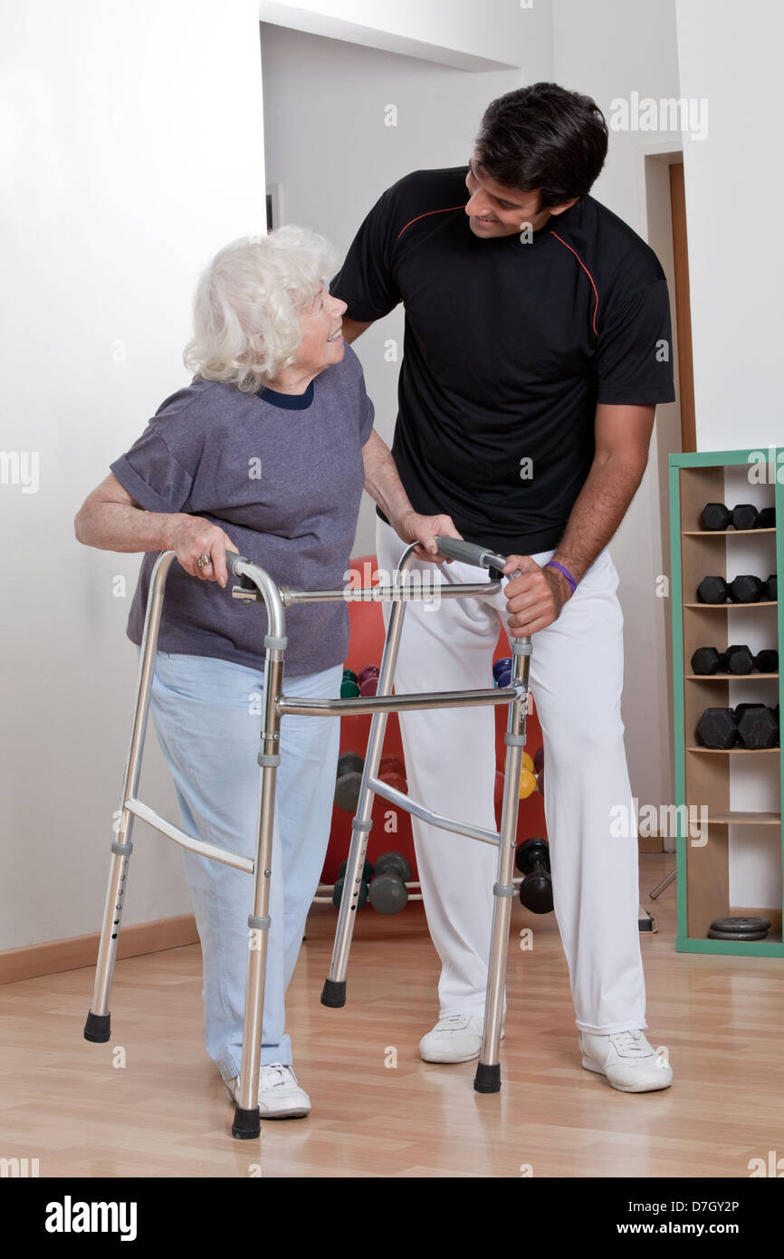 Therapist helping Patient use Walker Stock Photo Alamy