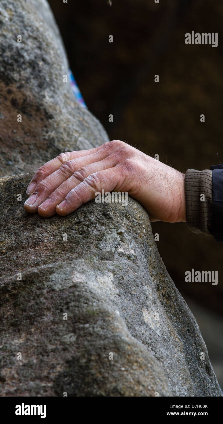 Climber's chalky hand on gritstone Stock Photo