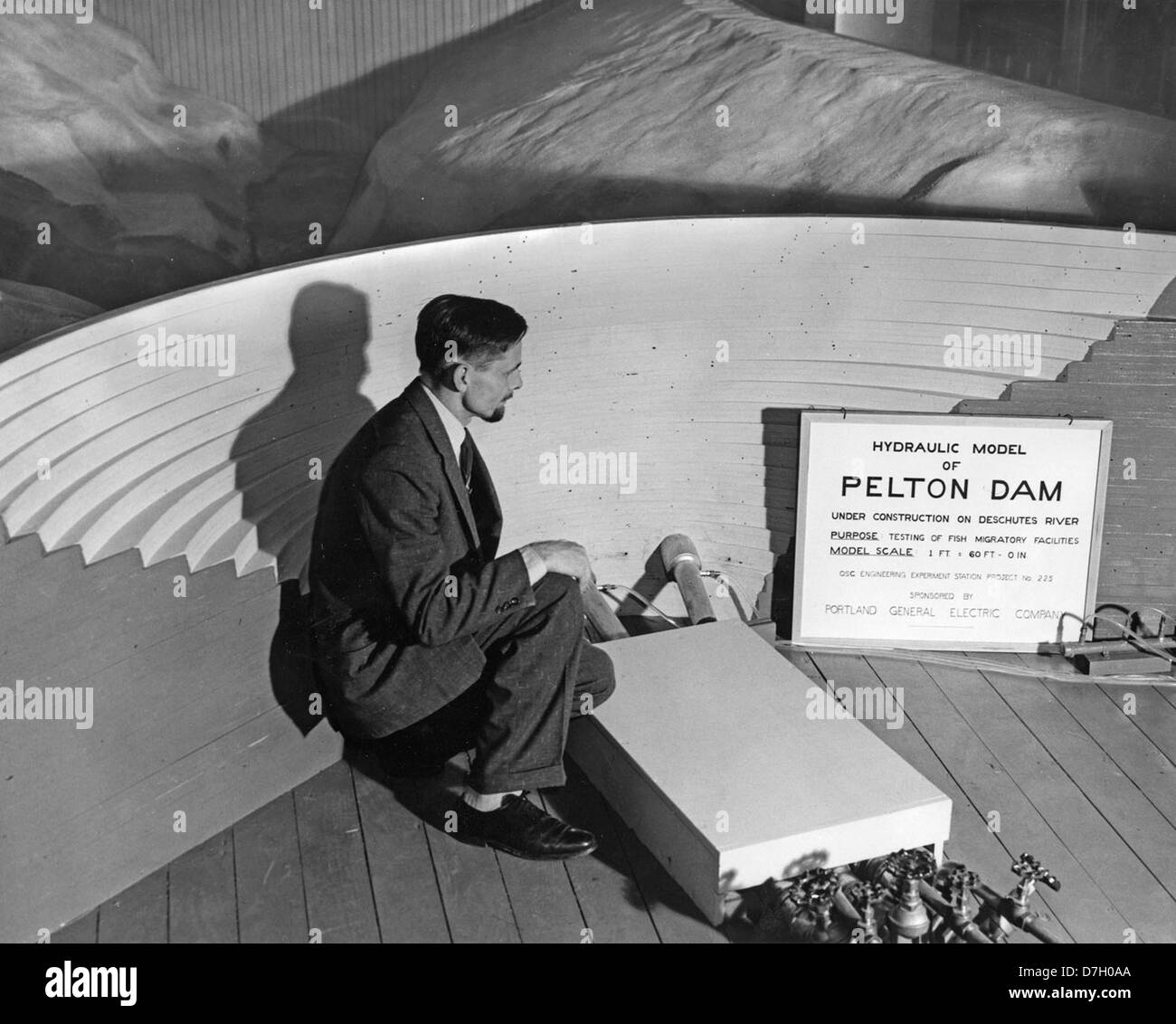 Professor Roy Shoemaker stands beside a scale model of the Pelton Dam ...